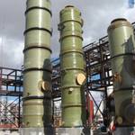 Tres tanques FRP de diámetro medio siendo instalados en una planta de procesamiento químico.