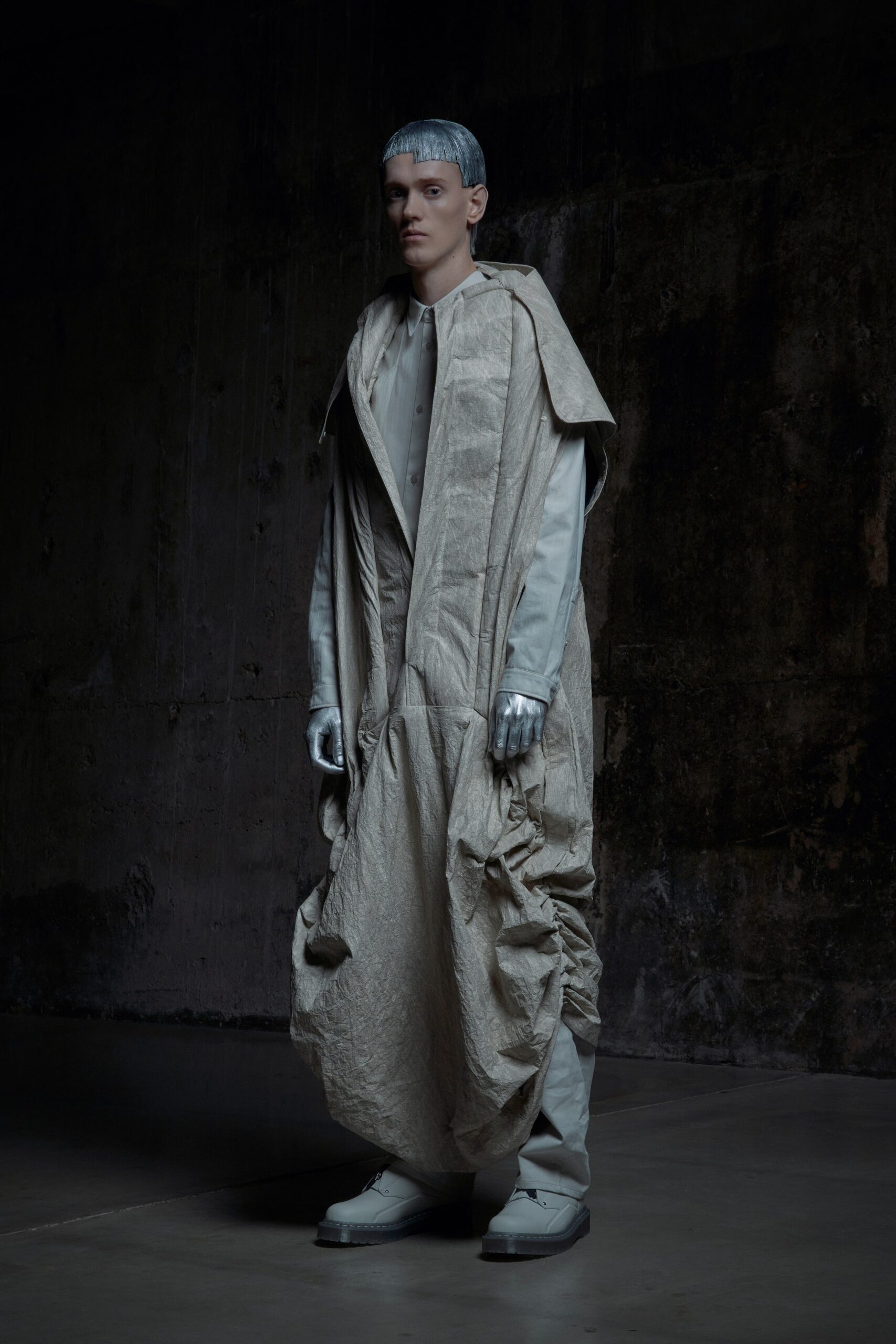 An oversized beige coat with long sleeves and a draped design.