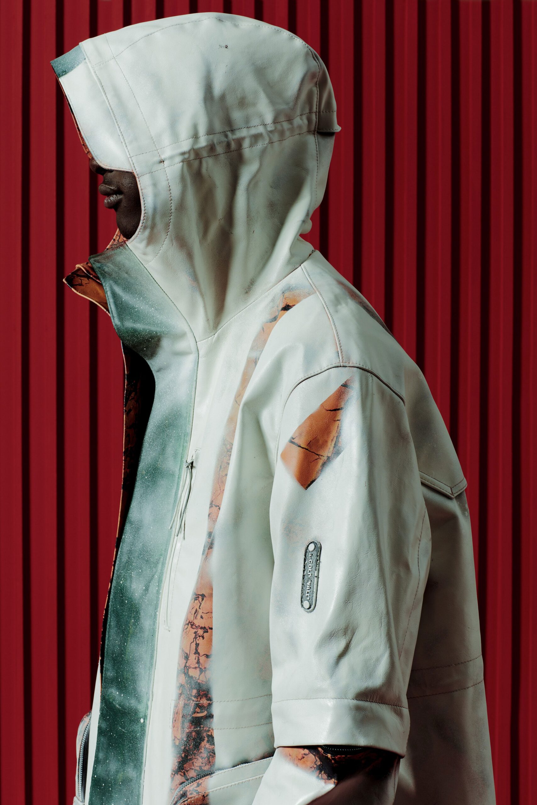 A relaxed white leather hooded jacket with an asymmetric design detail.