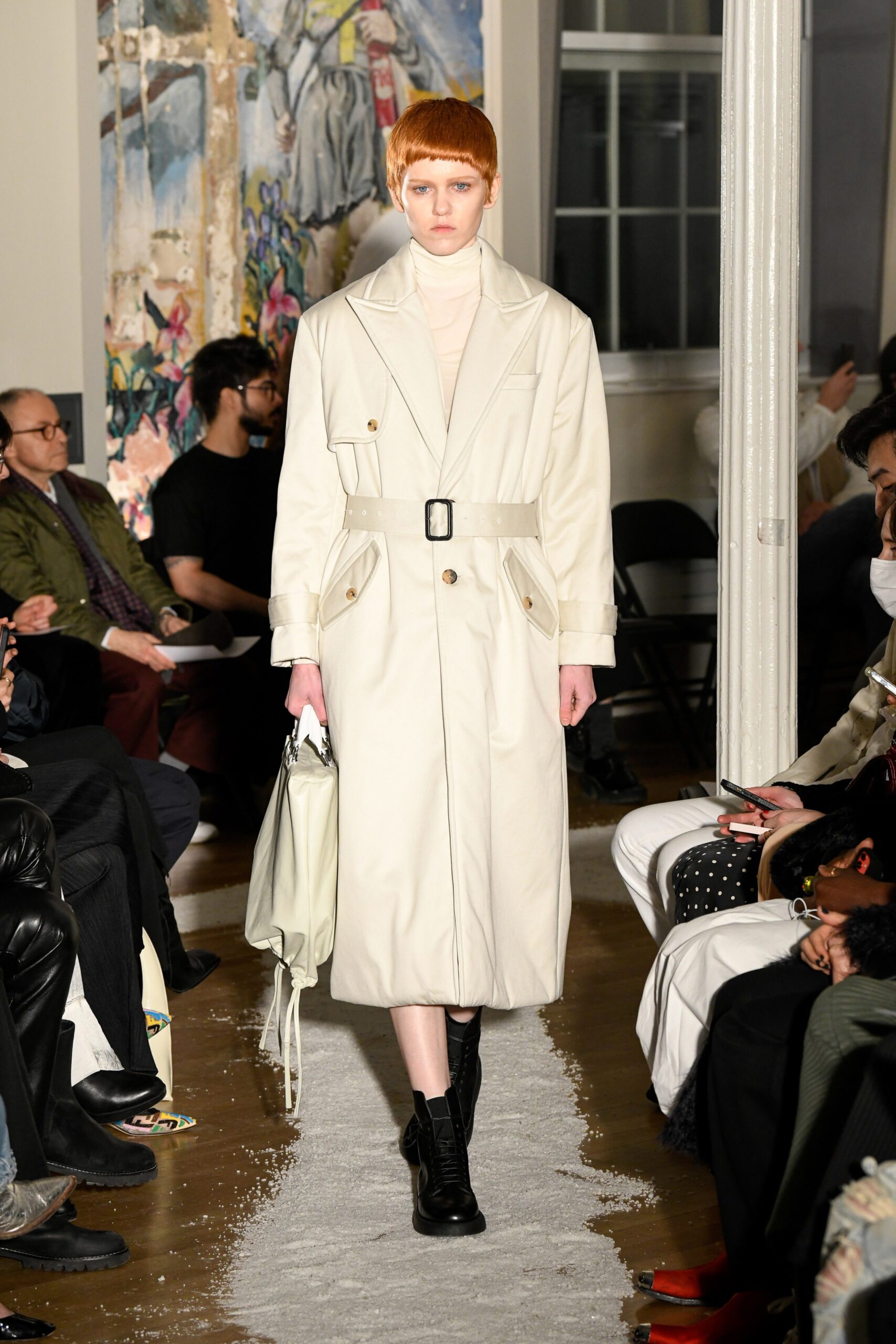 A fitted white cotton coat with long sleeves, a collared neckline, and a belted design.