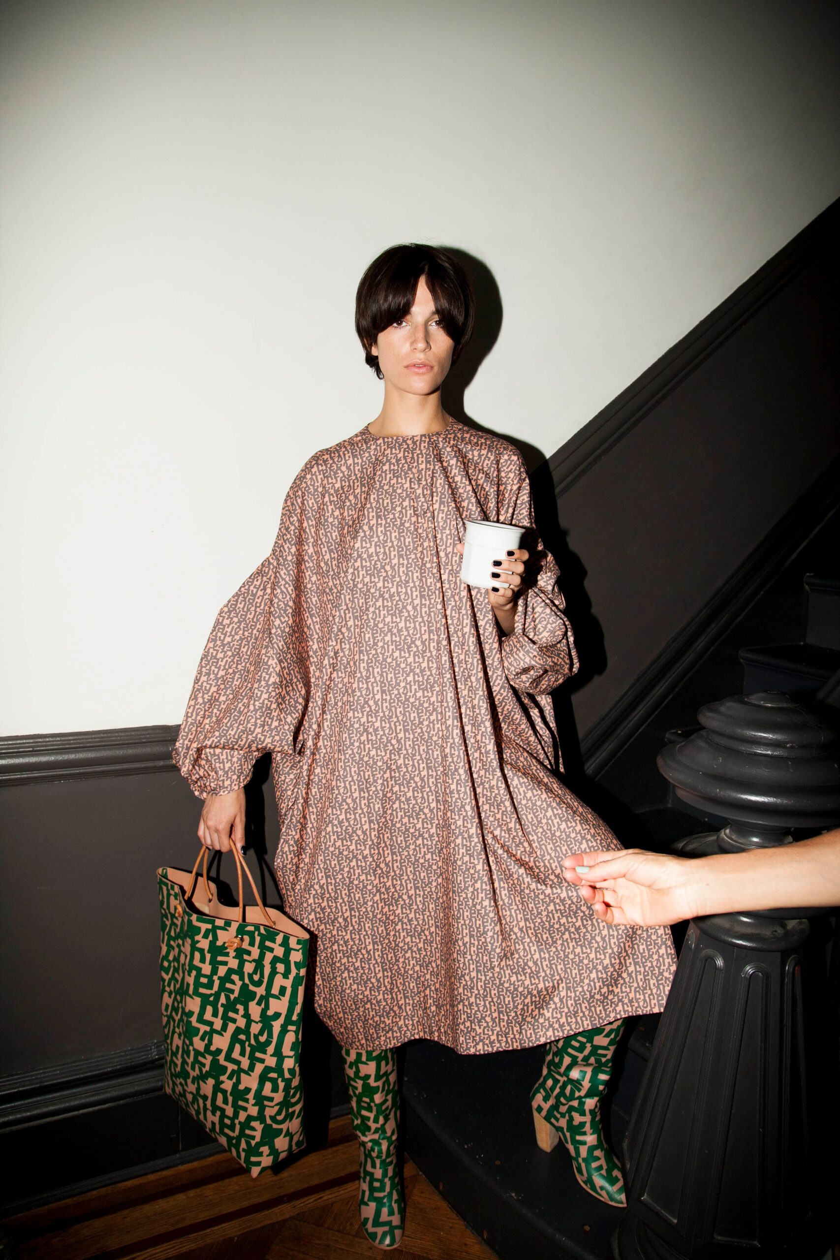 A relaxed brown printed dress with long sleeves and a collared neckline.