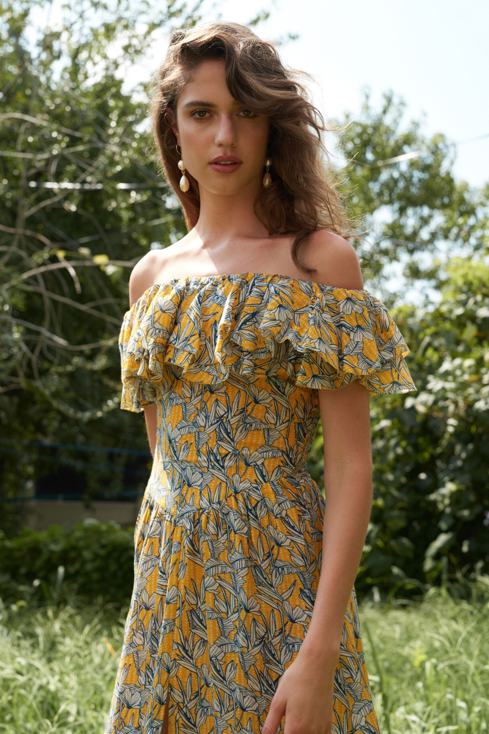A fitted yellow cotton off-shoulder dress with a flared silhouette and ruffled detailing.