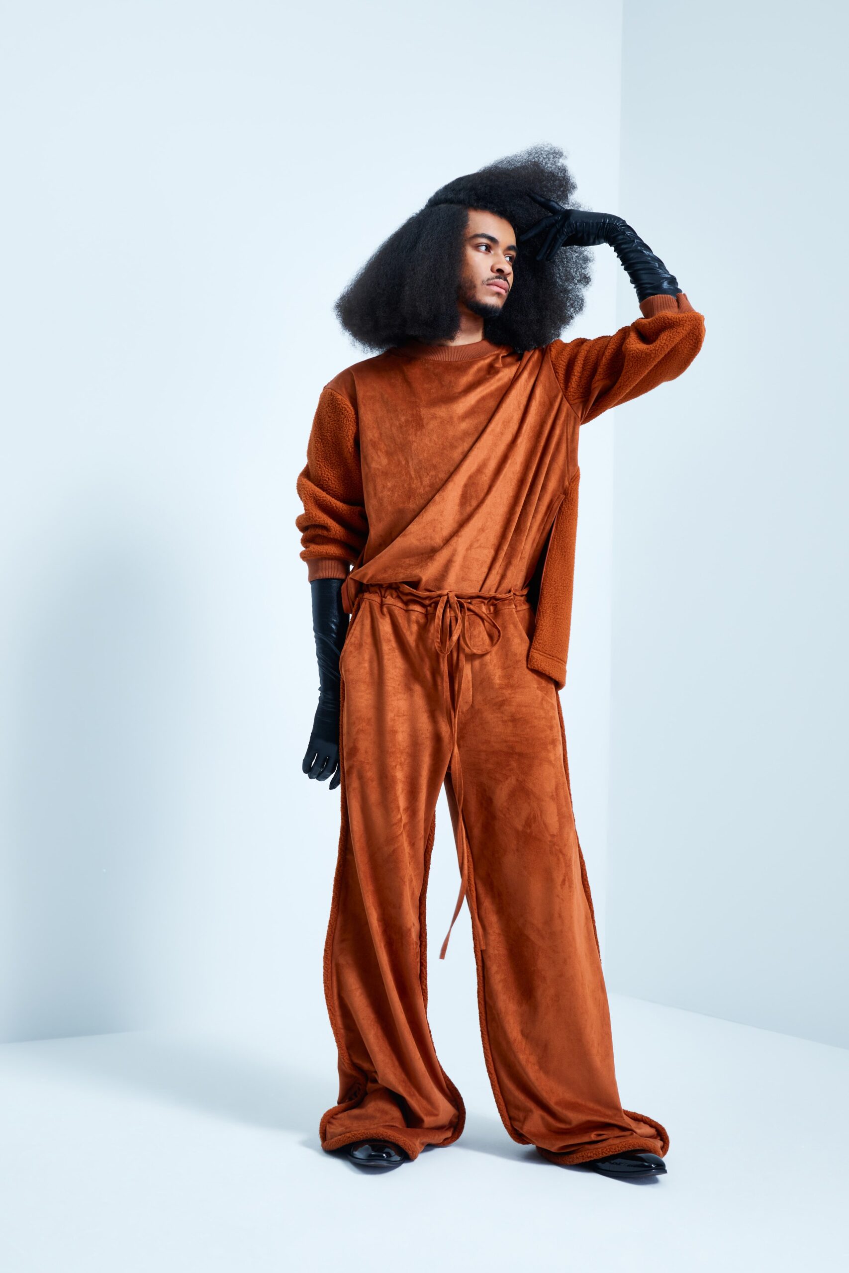 This ensemble features a relaxed top and wide-leg pants crafted from sumptuous orange velvet. The long sleeves and collared design create a flowing silhouette that enhances movement, while the rich texture adds depth and visual interest.