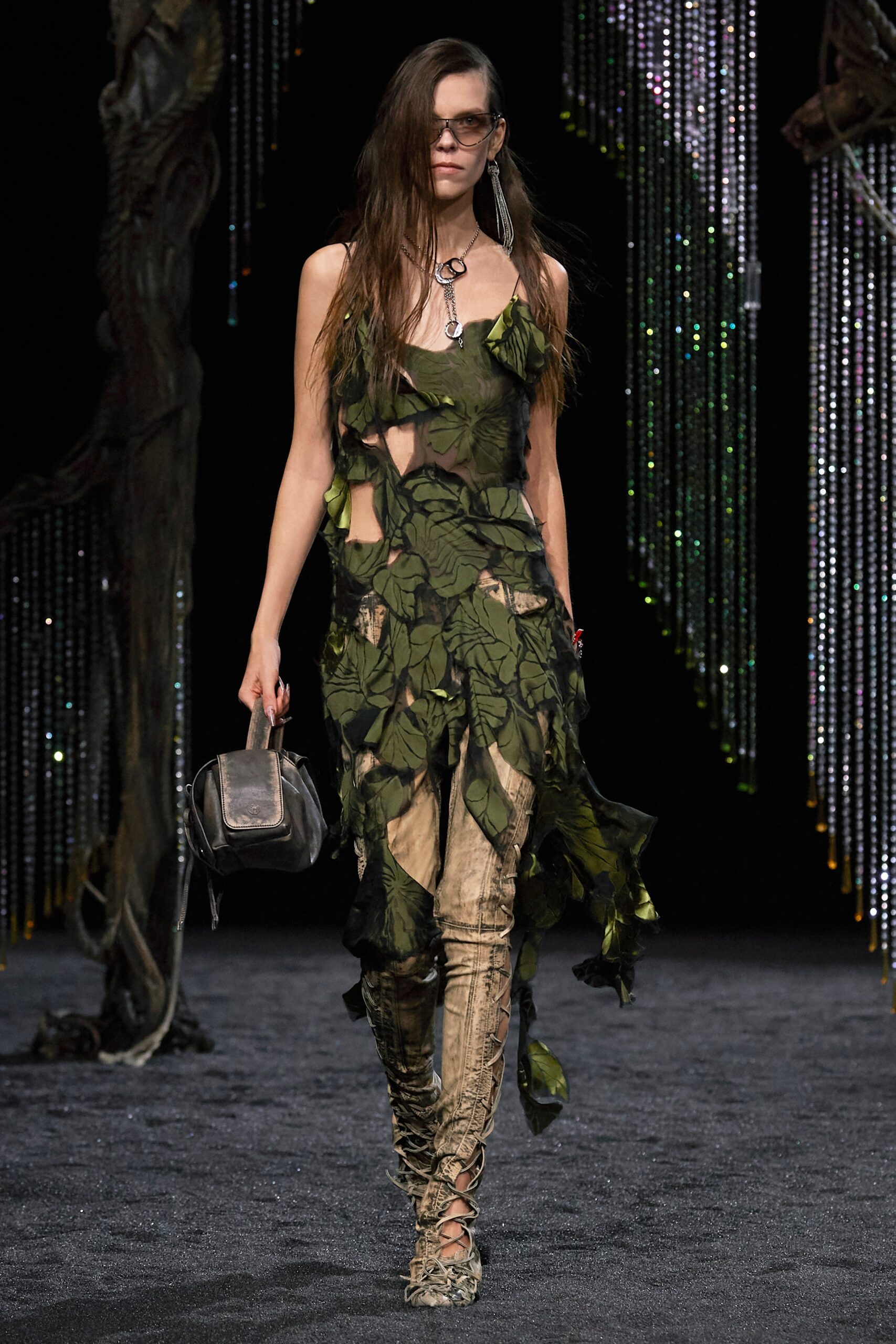 A fitted green sleeveless dress with an asymmetric design and layered details.