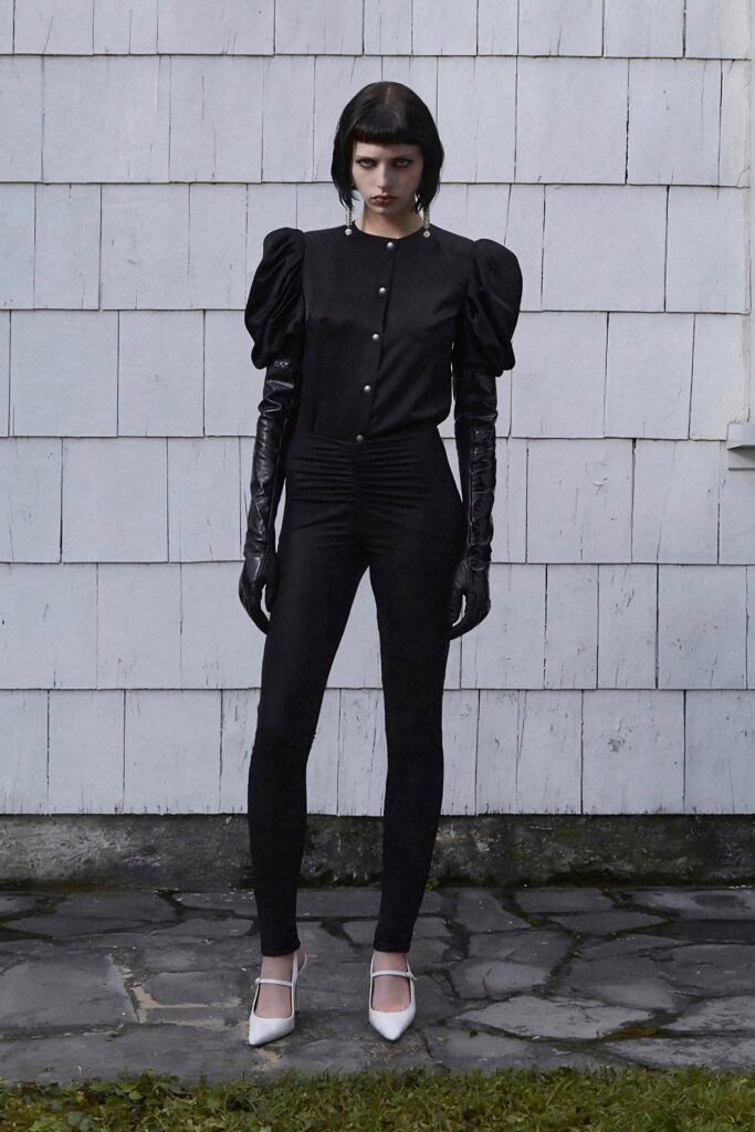 A fitted black top with puffed sleeves paired with sleek black pants.