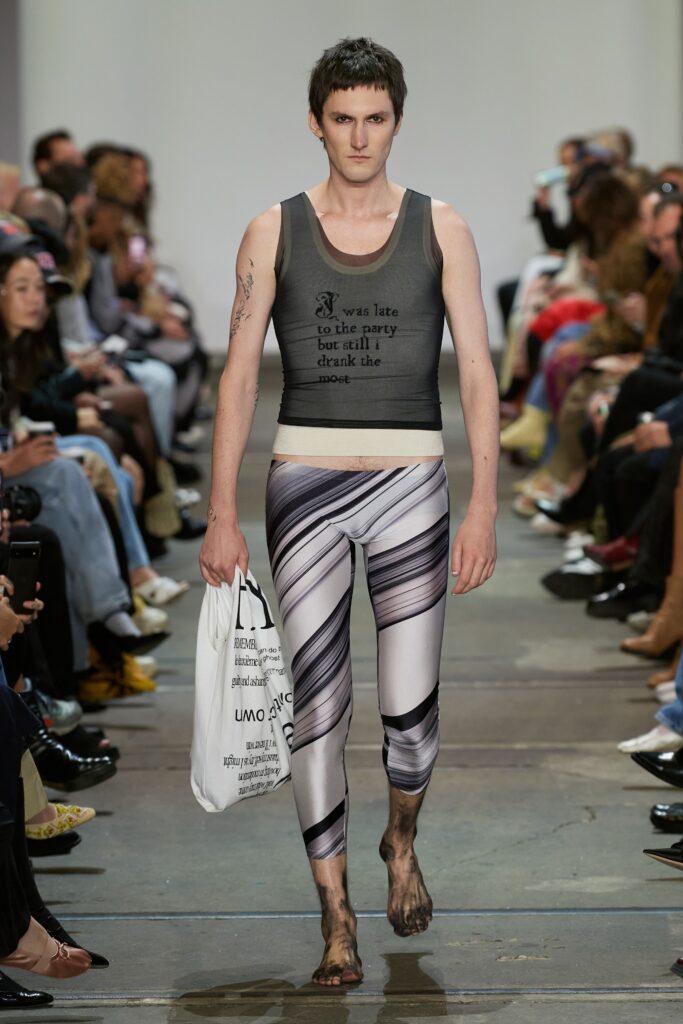 A fitted gray tank-top with a printed design paired with high-waisted black leggings.