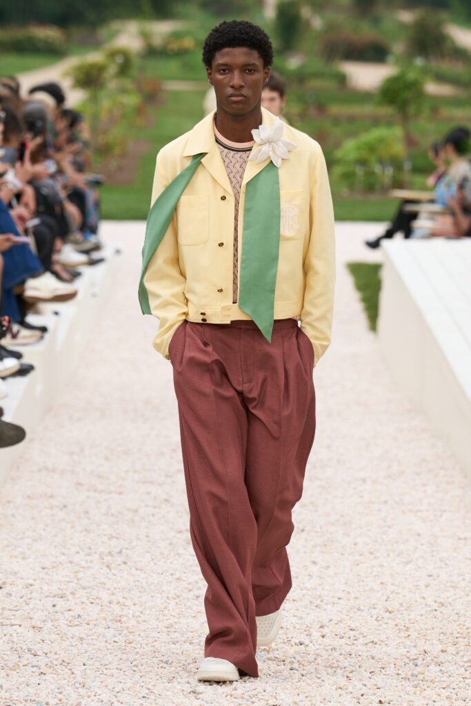 A relaxed yellow cotton jacket with a collared neckline paired with wide-leg brown pants.