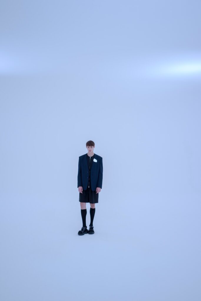 A relaxed black blazer with long sleeves and a collared design, paired with matching shorts.