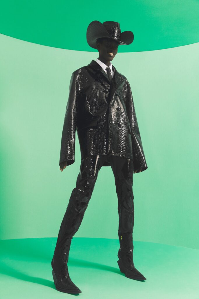 An oversized black leather jacket paired with fitted black leather pants, creating a bold silhouette.