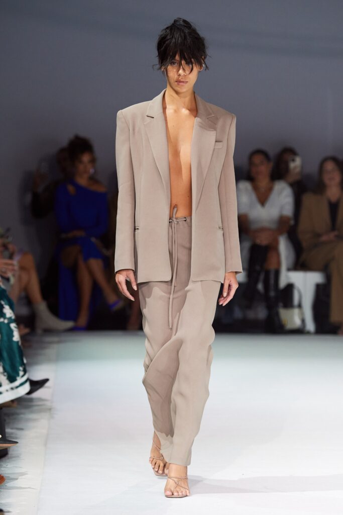 A relaxed beige blazer paired with matching pants, featuring a collared design and straight-leg fit.