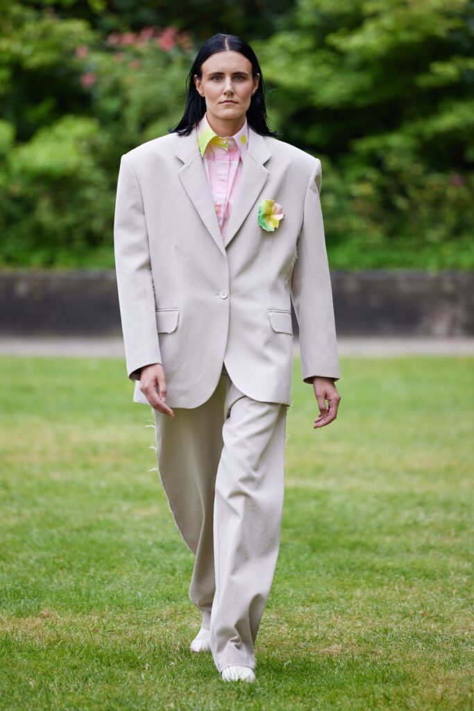 An oversized beige suit with a buttoned jacket and wide-leg trousers, exuding a modern aesthetic.