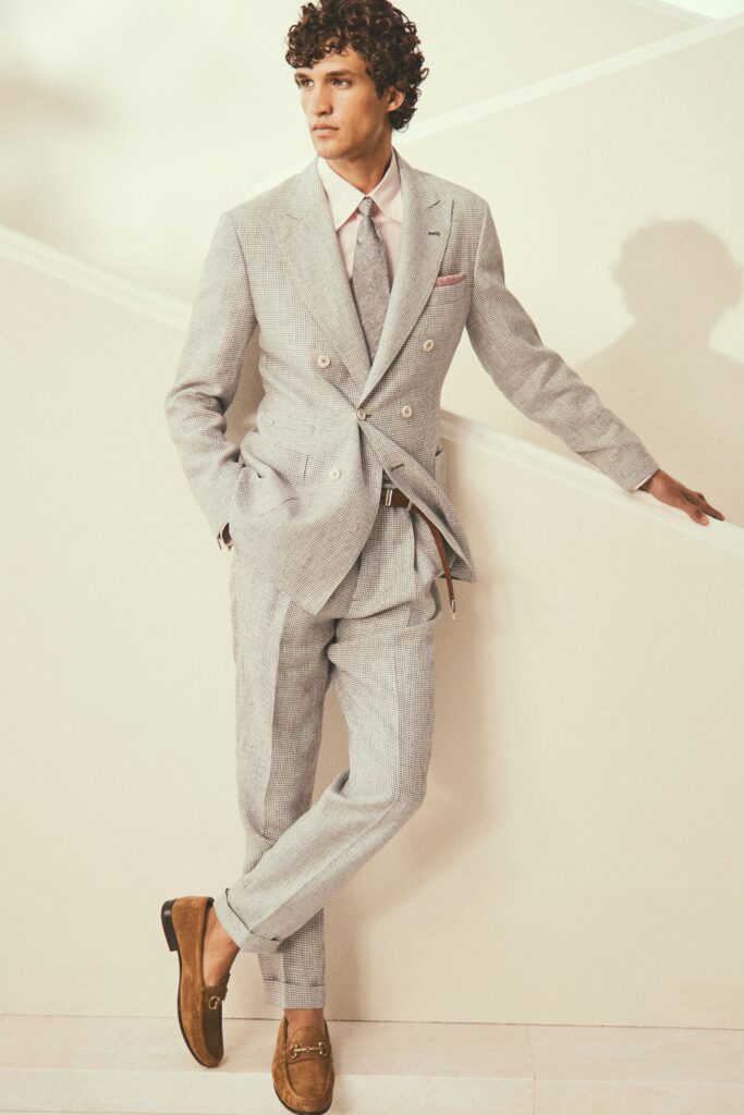 A tailored gray suit with long sleeves, a collared shirt, and buttoned details.