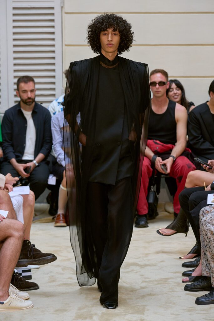 A relaxed black silk coat with long sleeves and layered design paired with matching pants.