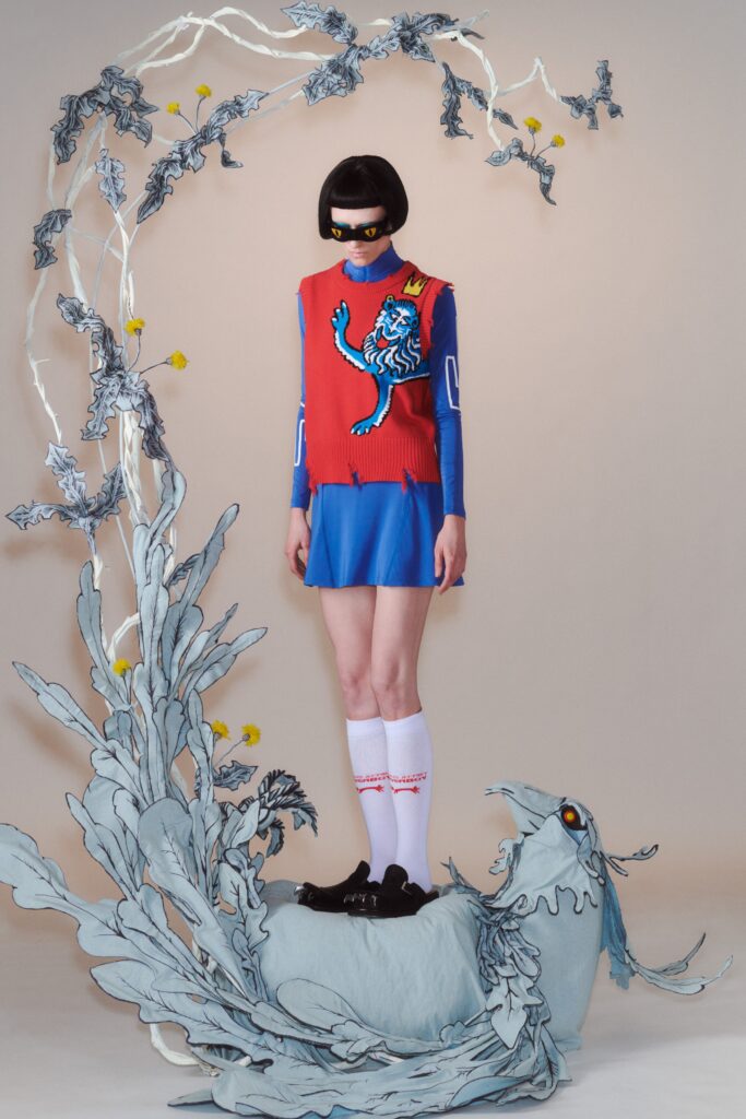 A fitted sleeveless dress in blue and red with a high-neck and printed design.