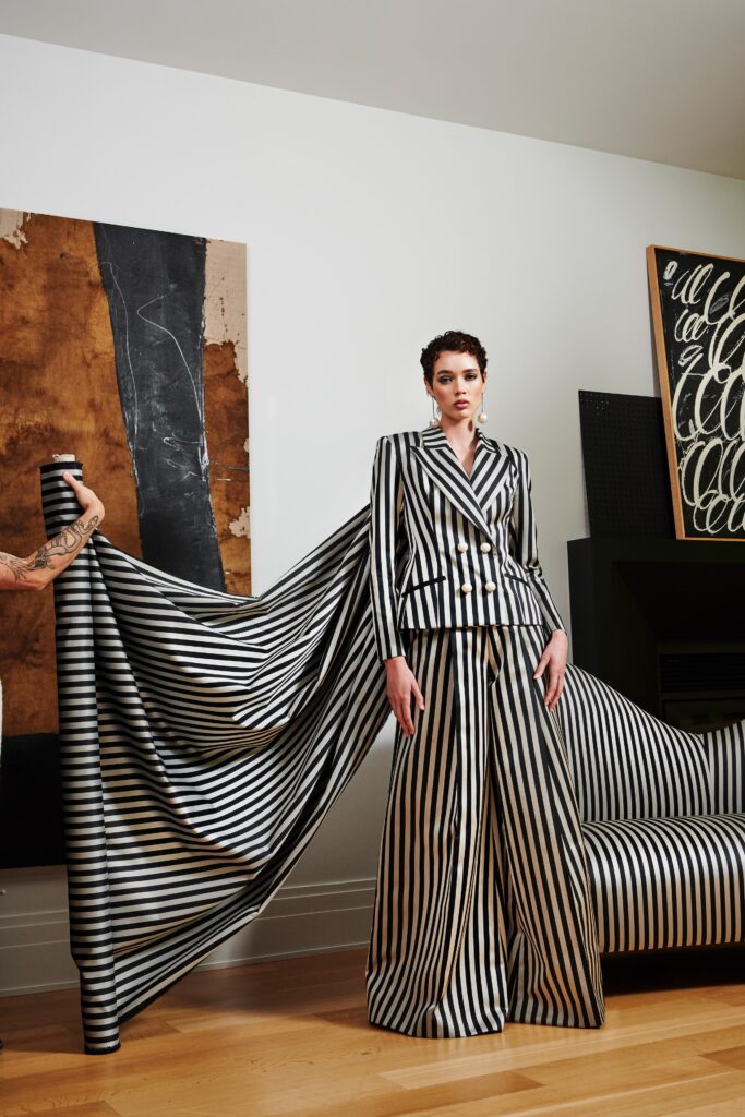 A tailored black and white striped suit with long sleeves and a collared design.