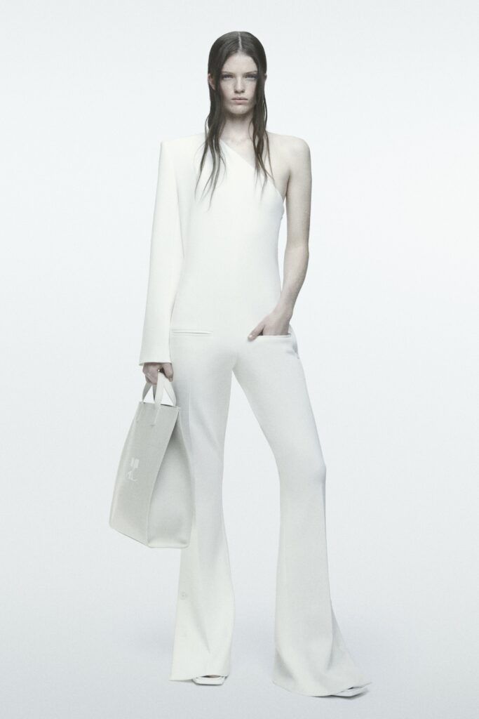 A fitted white sleeveless jumpsuit with a high neckline and flared legs.