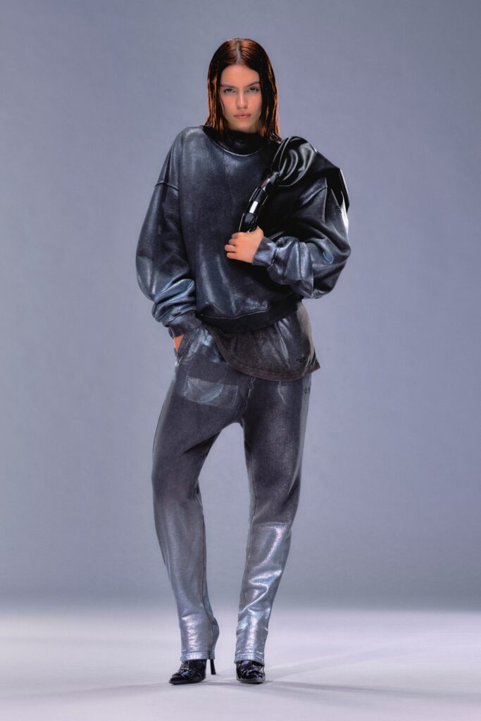 A relaxed gray silk long-sleeve sweater paired with asymmetric pants for a modern look.