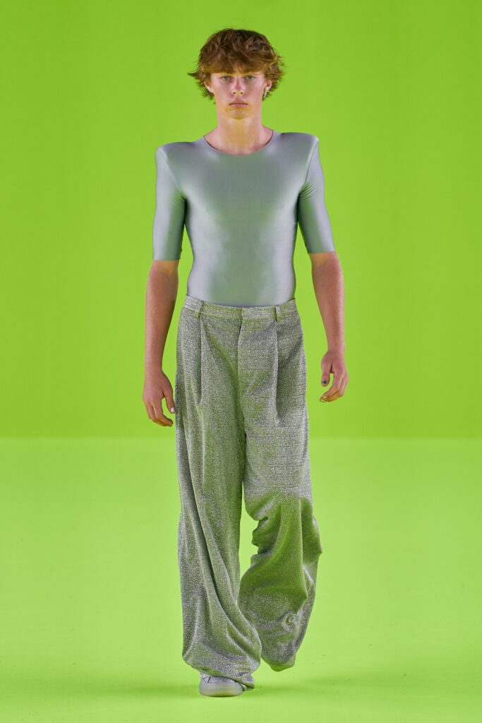 A relaxed silver metallic top with short sleeves paired with pleated pants.