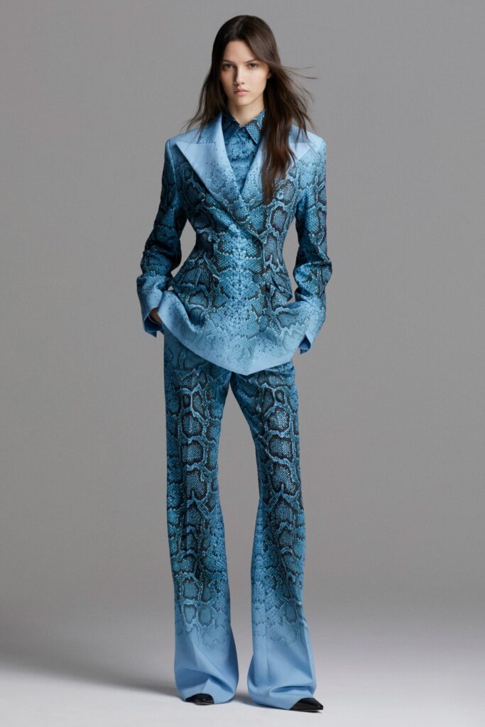 A fitted blue silk suit with a collared long-sleeve shirt and flared pants featuring a snake print.