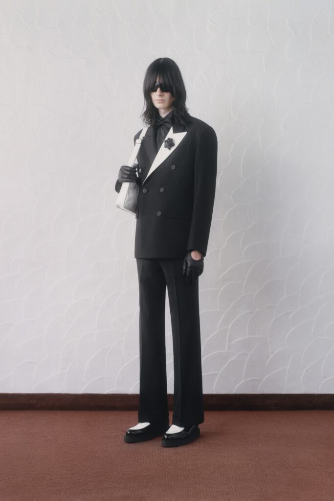 A tailored black and white suit with long sleeves and a collared design, featuring straight-leg trousers.