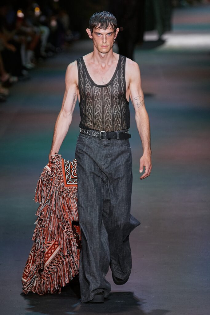 A relaxed black sleeveless top paired with wide-leg gray pants, showcasing a layered design.