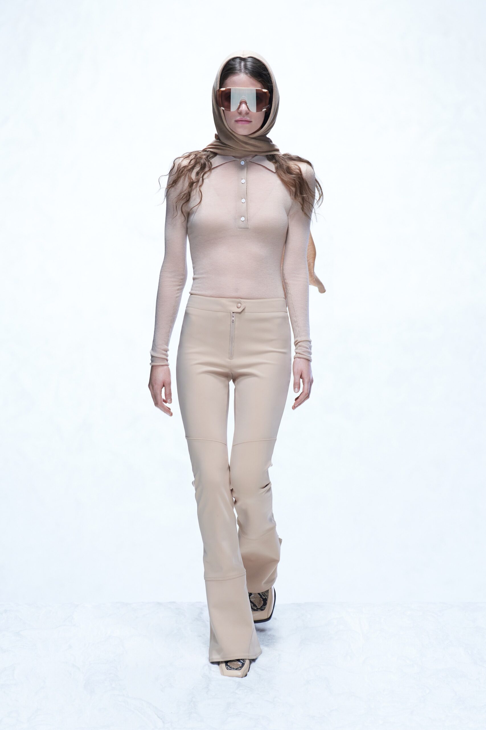 A fitted beige leather long-sleeve top with collared detail paired with straight-leg pants.
