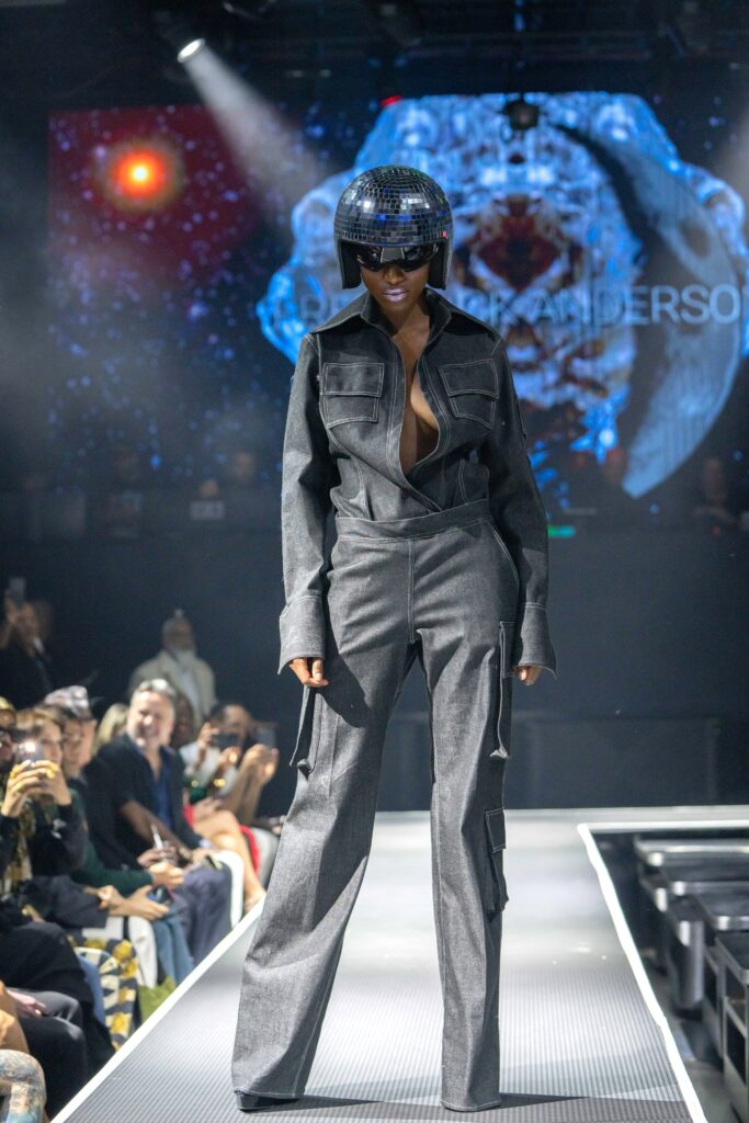 A fitted gray denim jumpsuit with long sleeves and a zippered front.