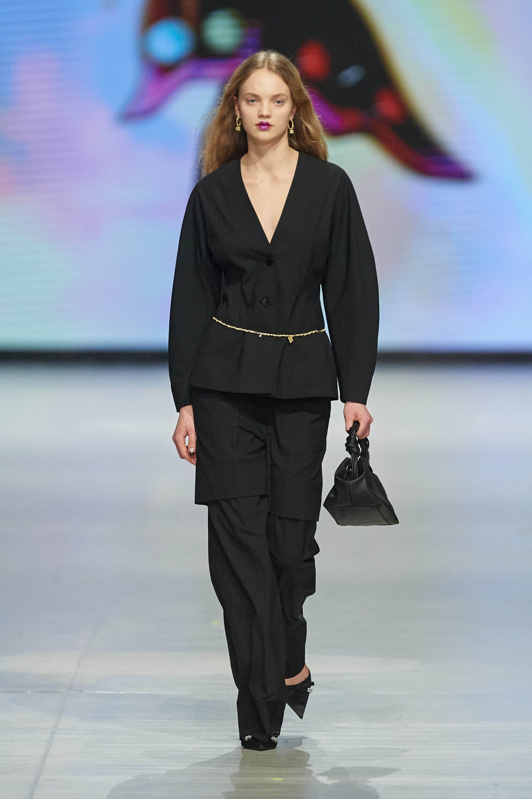 A fitted black blazer with a V-neckline paired with tailored black pants.
