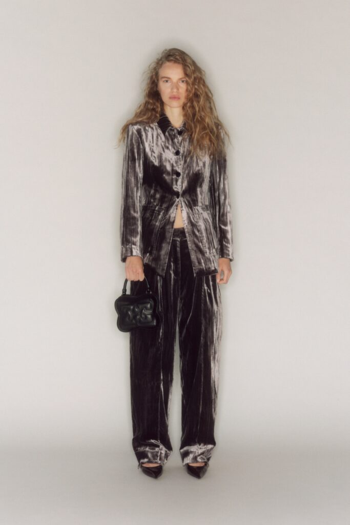 A relaxed black velvet suit with long sleeves and a collared design, featuring a buttoned front.