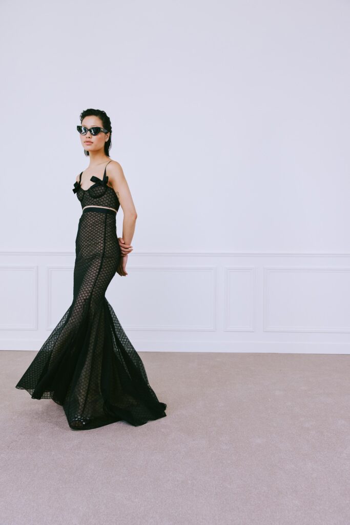 A fitted black mesh dress with a V-neckline and tiered silhouette.