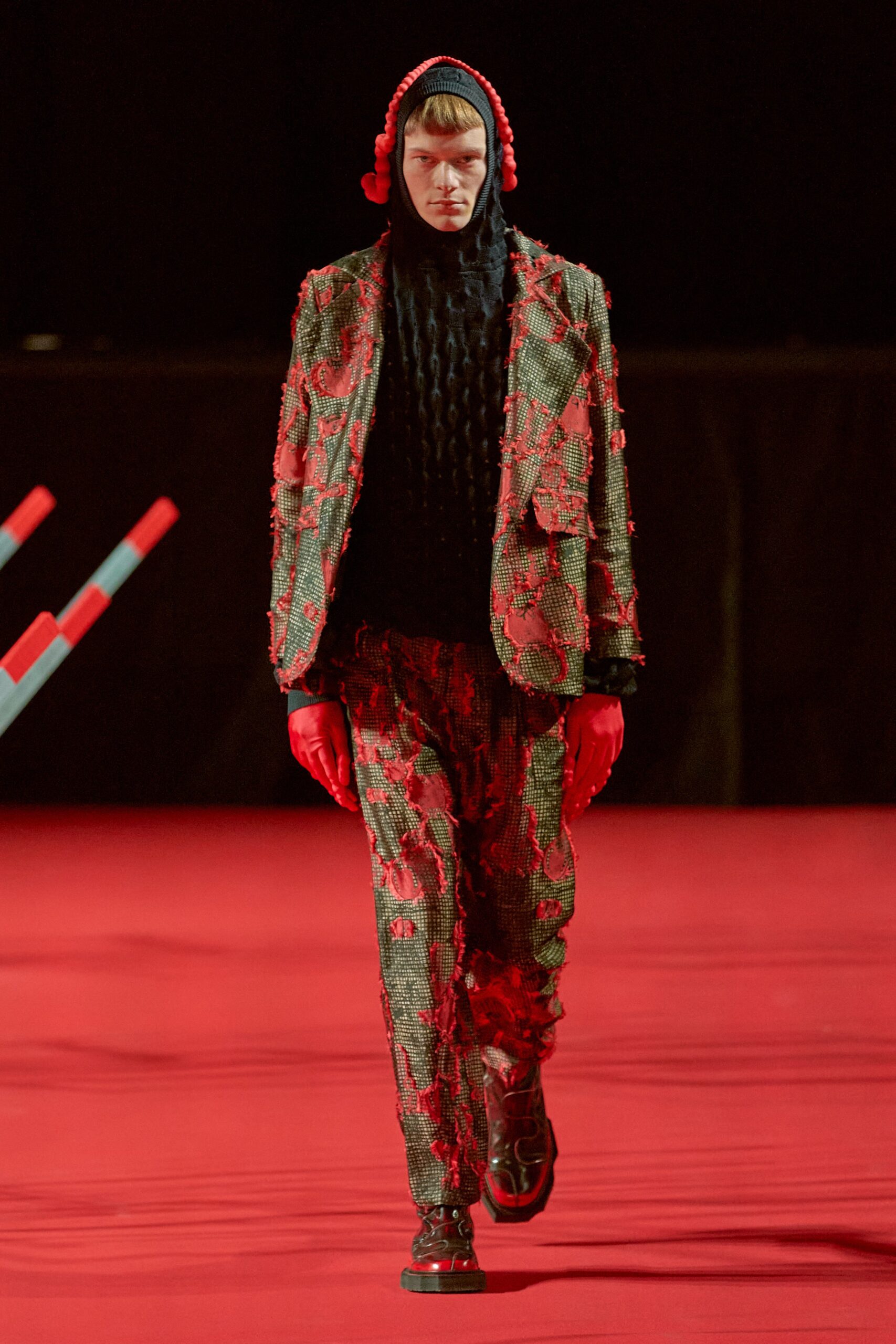 A fitted red and black printed suit with long sleeves and a collared design.
