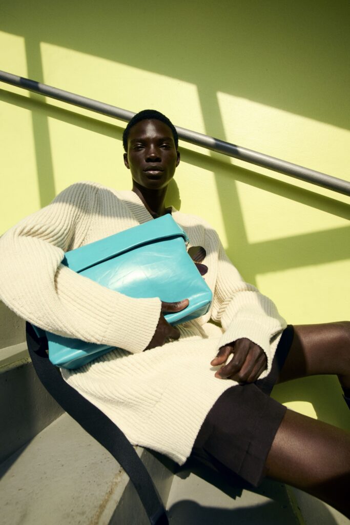 A relaxed cream long-sleeve sweater paired with black shorts, creating a stylish layered look.