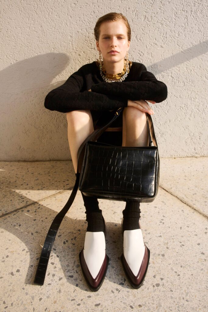 A fitted black long-sleeve top paired with a white asymmetric skirt for a chic look.