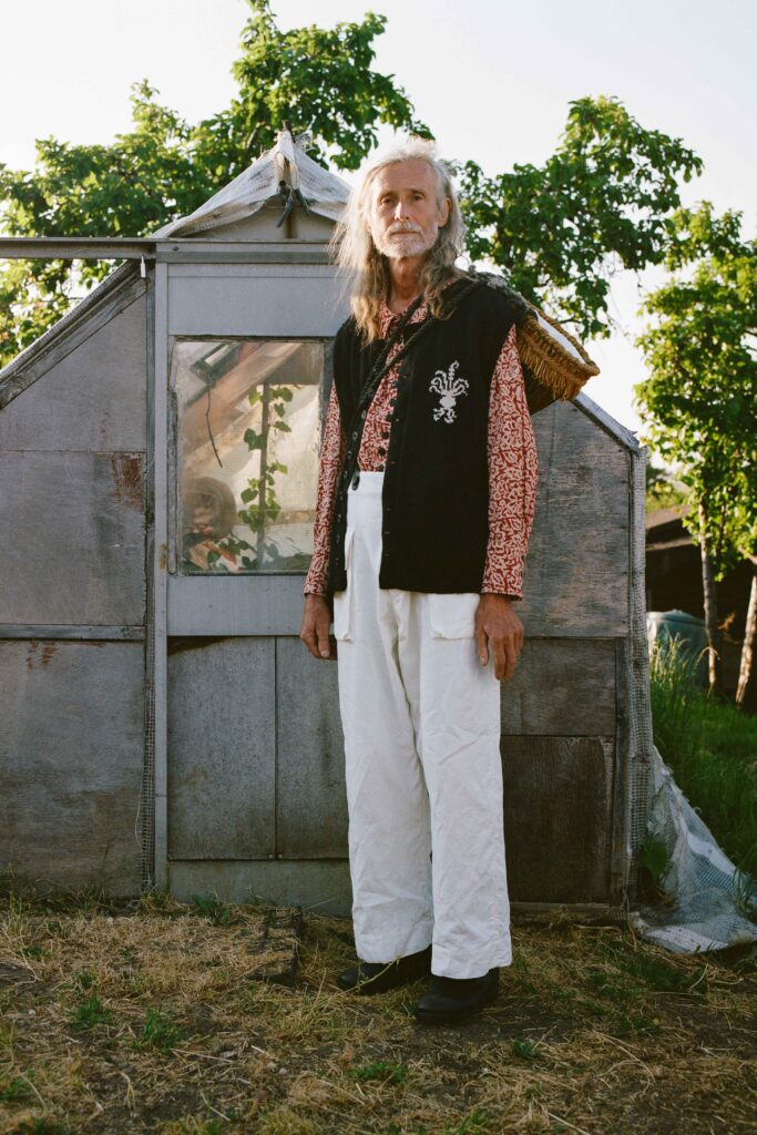 A relaxed black sleeveless vest paired with white pants featuring a printed design.