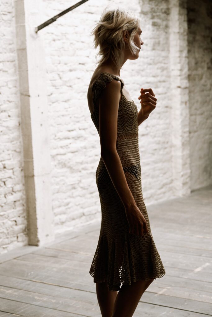A fitted beige cotton dress with a sleeveless design and flared hem.