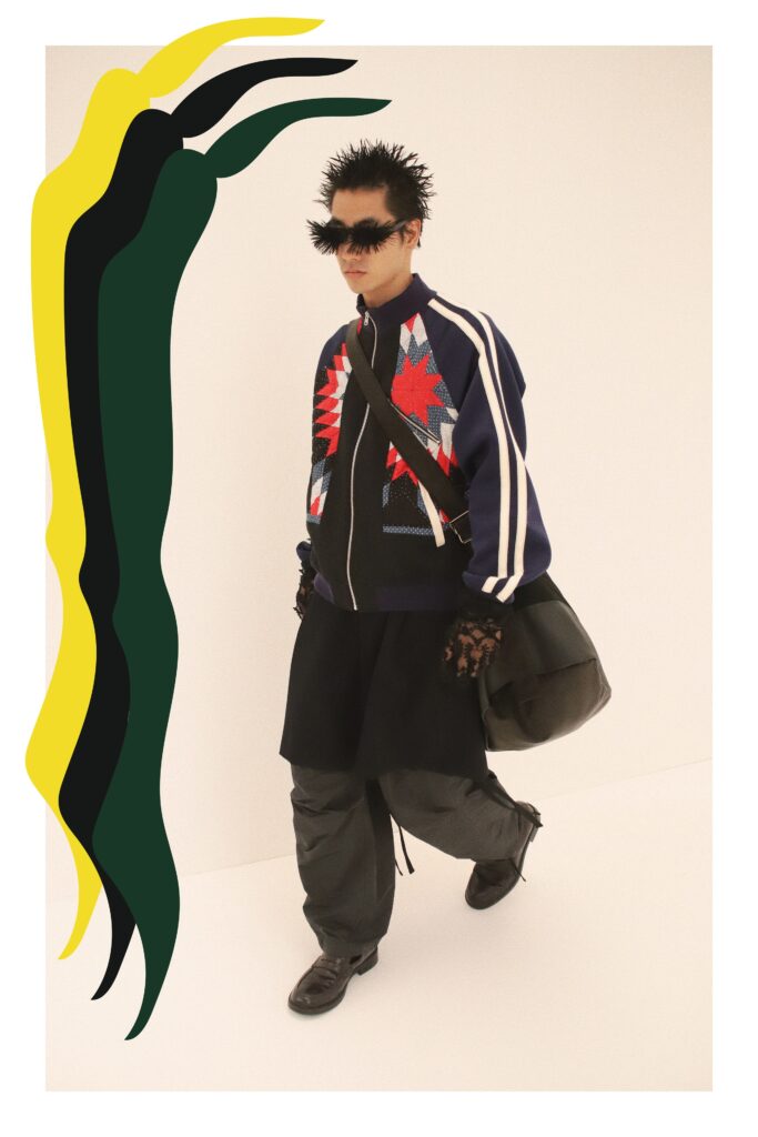 An oversized blue jacket paired with black pants, featuring a zippered front and unique design elements.