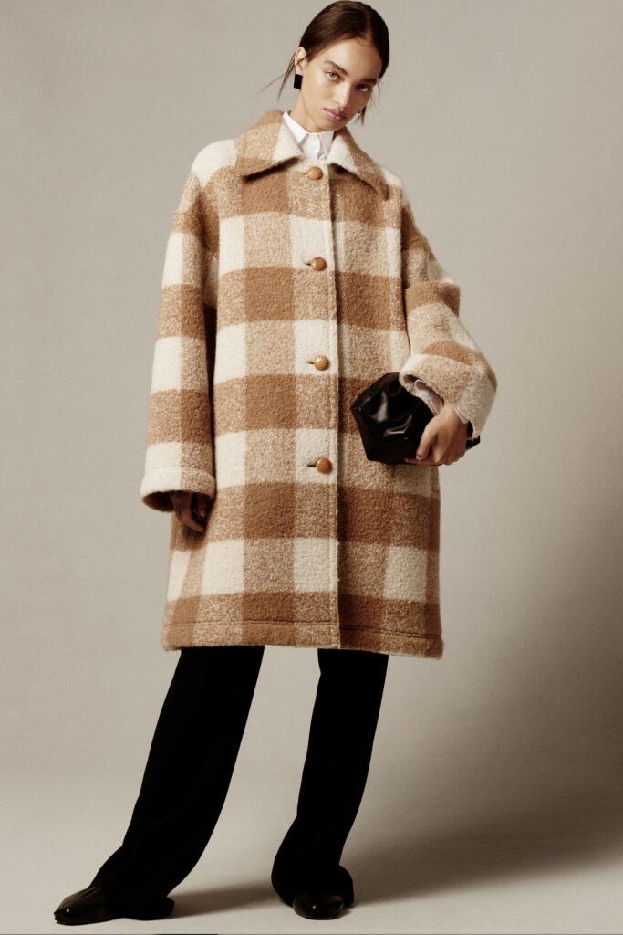 A relaxed fit checked wool coat paired with black pants, featuring a collared design.