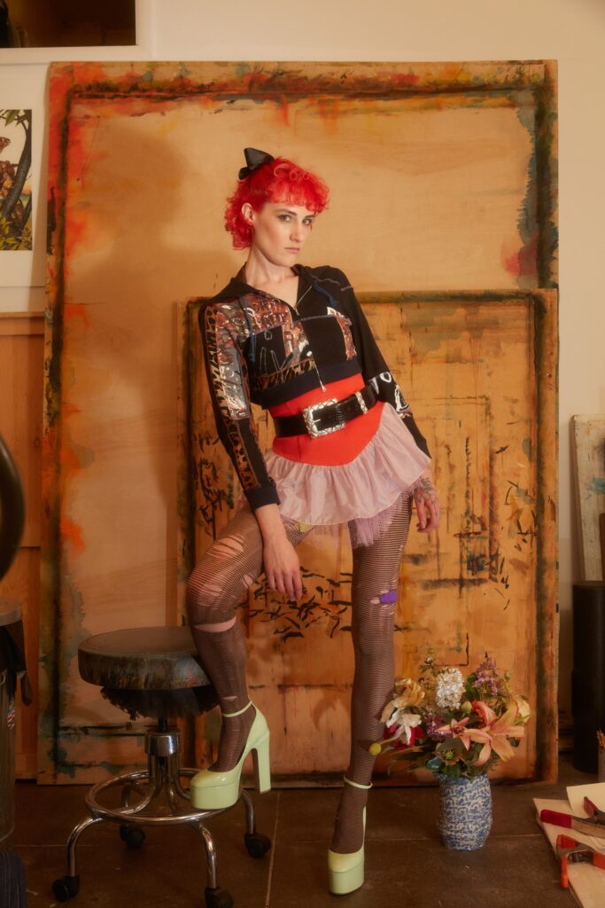 A fitted black long-sleeve top with a collared design paired with a layered pink skirt.