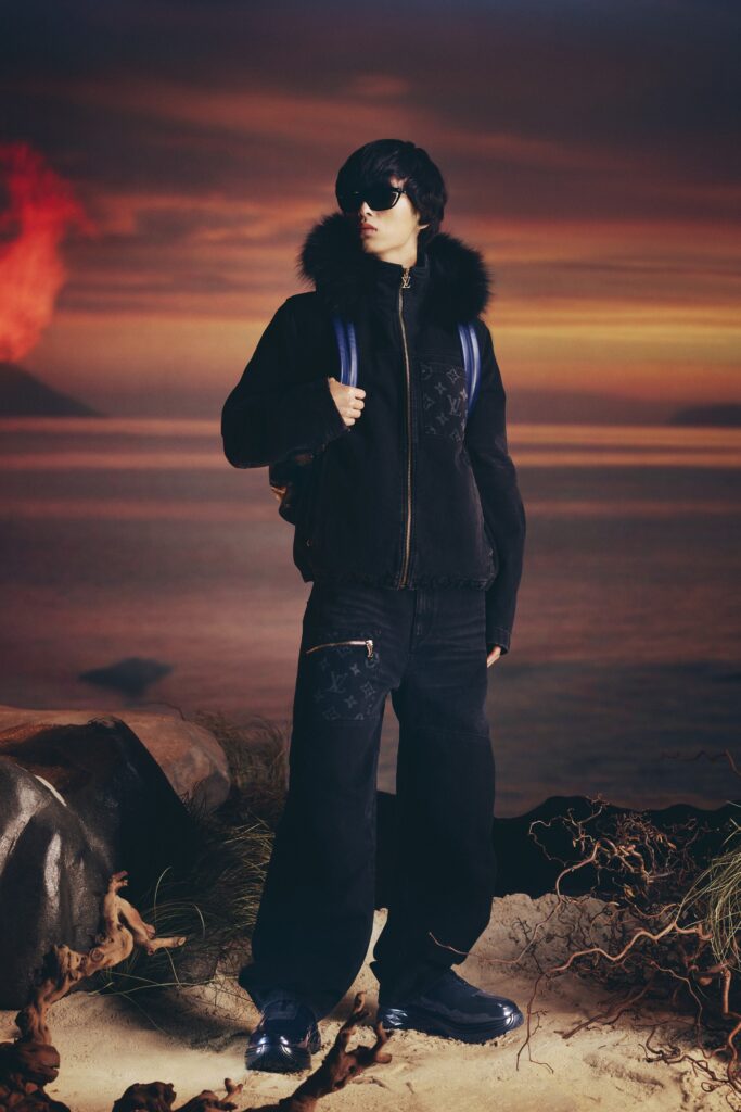 A relaxed black faux-fur jacket with a collared neckline paired with wide-leg black denim pants.