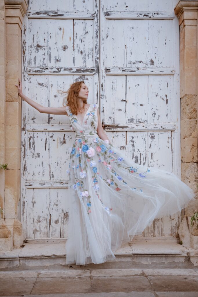 A fitted white tulle sleeveless dress with a V-neckline and flared silhouette.
