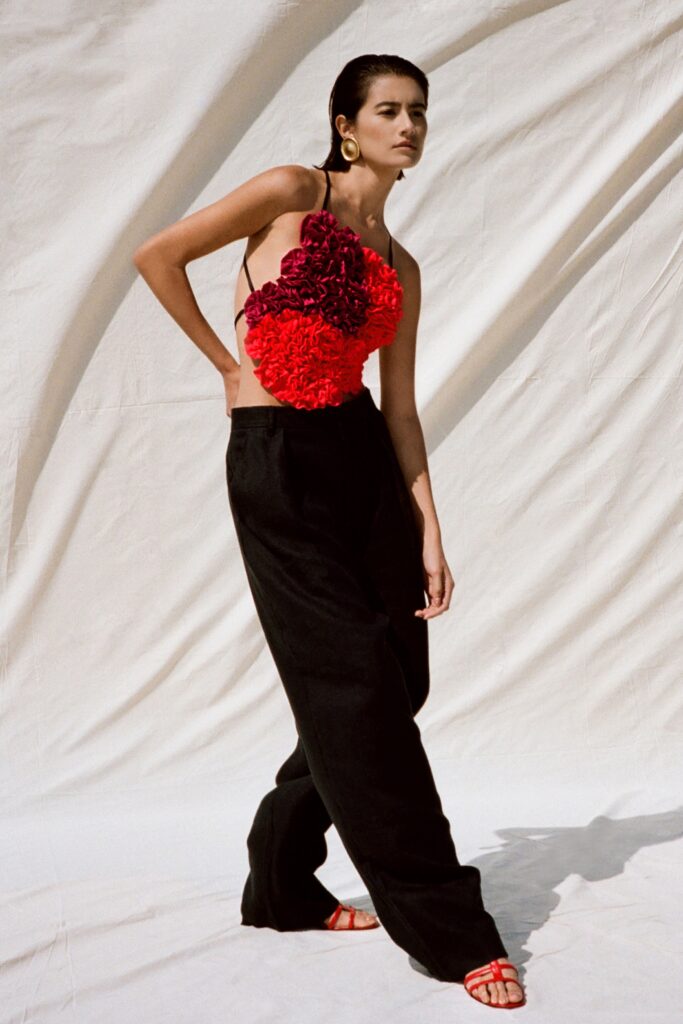 A relaxed fit sleeveless red floral top paired with relaxed black pants.