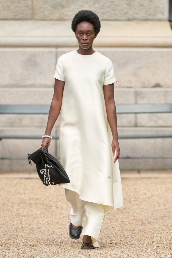 A relaxed cream silk dress with short sleeves and an asymmetric design.