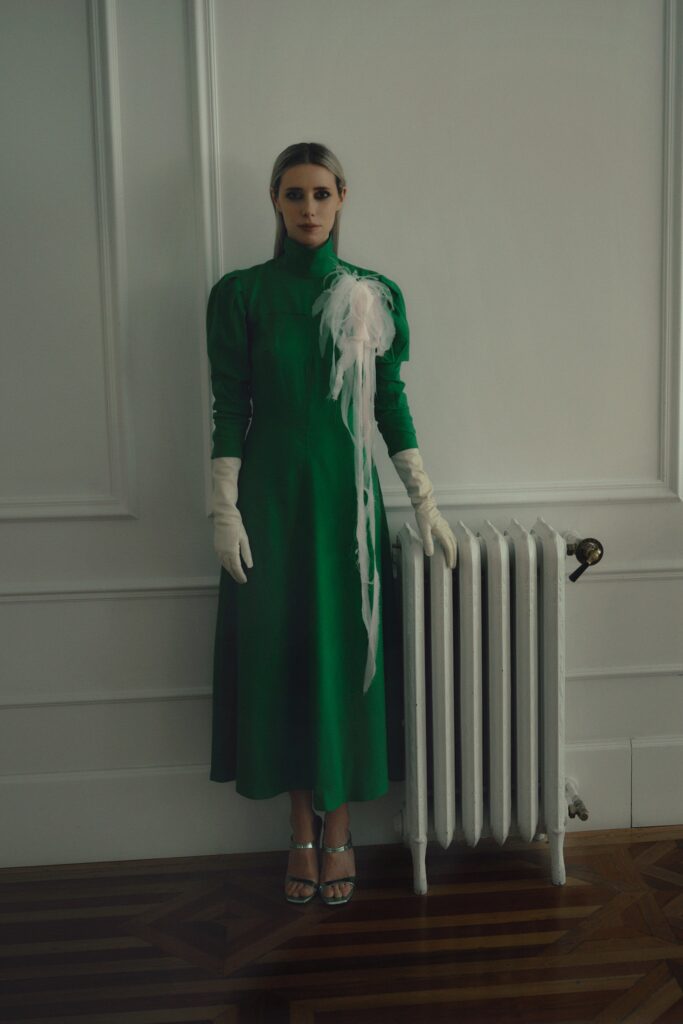 A fitted green silk dress with long sleeves and a high neckline in an A-line silhouette.