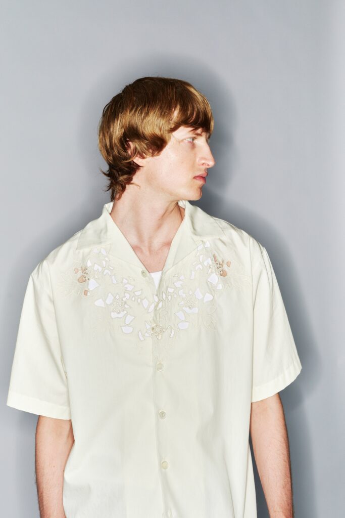 A relaxed yellow cotton shirt with short sleeves and embroidered detailing.