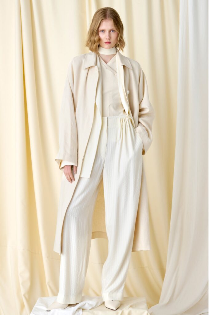 A relaxed beige coat paired with straight-leg pants, featuring a collared design.