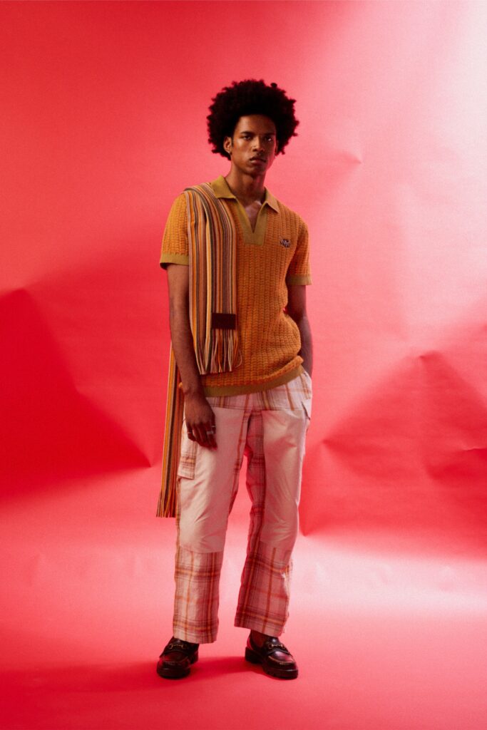 A relaxed-fit orange striped shirt with short sleeves paired with checked white pants.