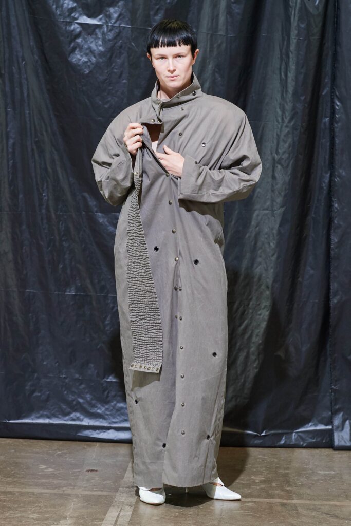 A relaxed gray cotton coat with long sleeves and a collared design, featuring button details.