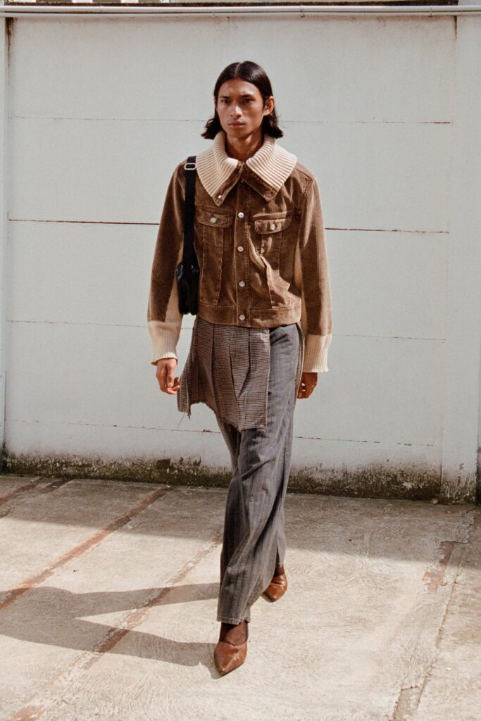 A relaxed brown cotton jacket with a collared neckline paired with gray straight-leg pants.