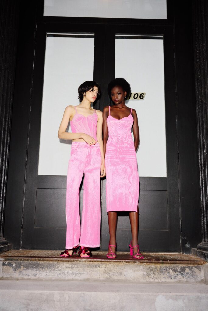 A fitted pink silk sleeveless dress with a V-neckline and a slit detail.