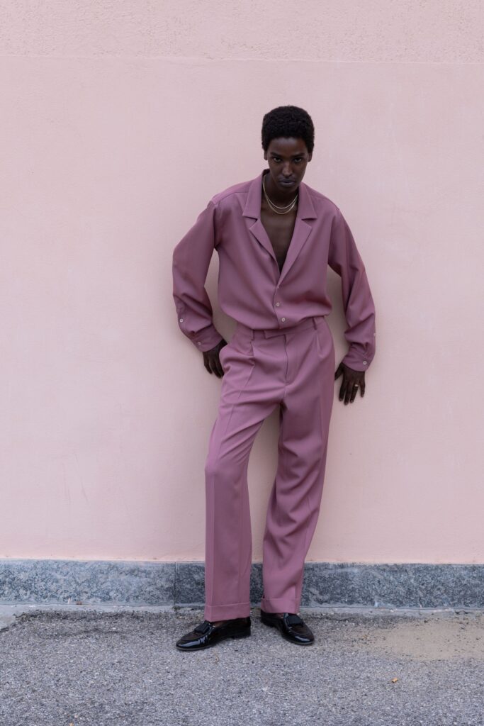 A relaxed pink long-sleeve collared shirt paired with straight-leg pants.